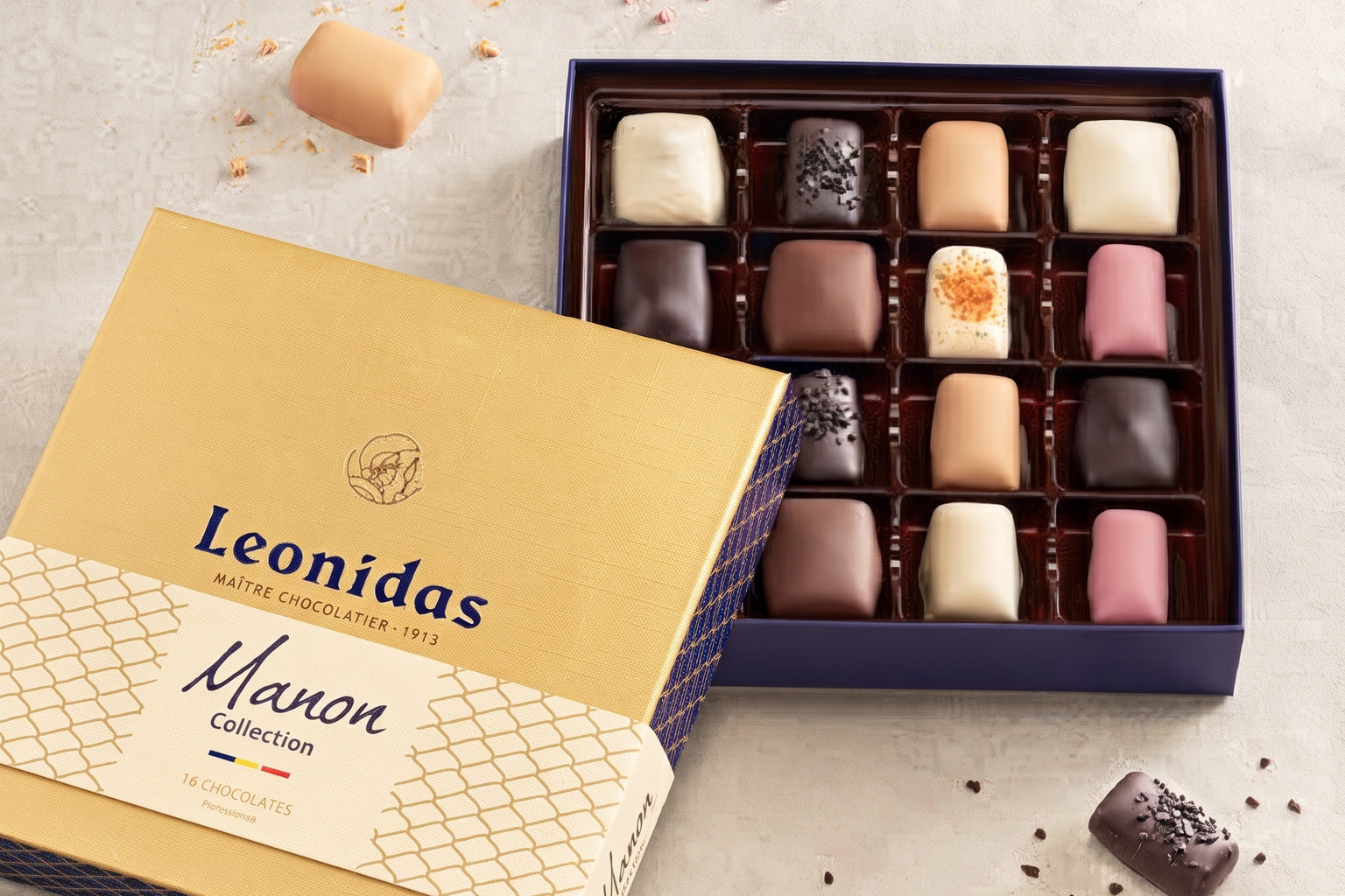 Des chocolats pastel présentés près d’un coffret doré